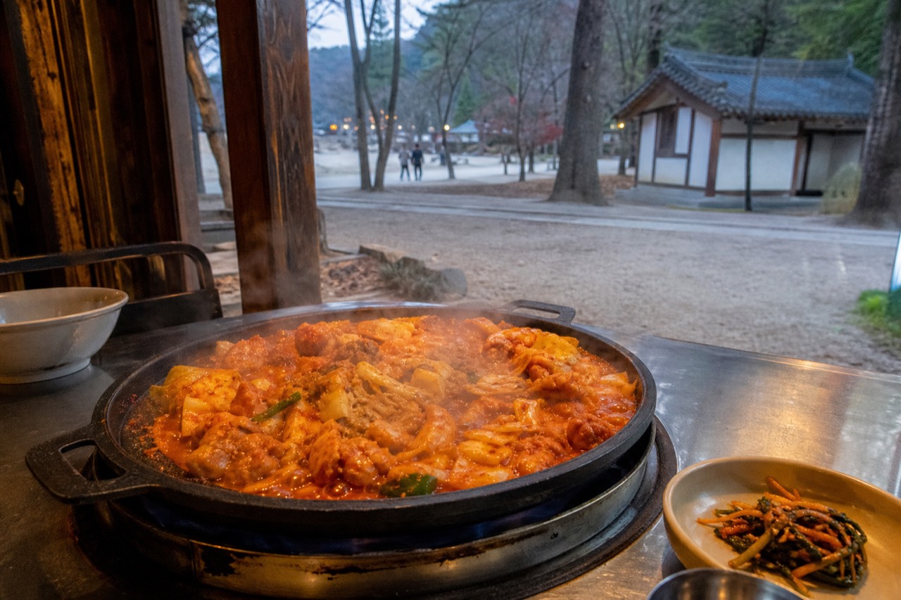 Dakgalbi sizzling on an iron plate at a Chuncheon restaurant, no text, no logos, no people